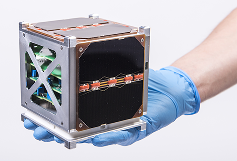 Hand holding a cube satellite